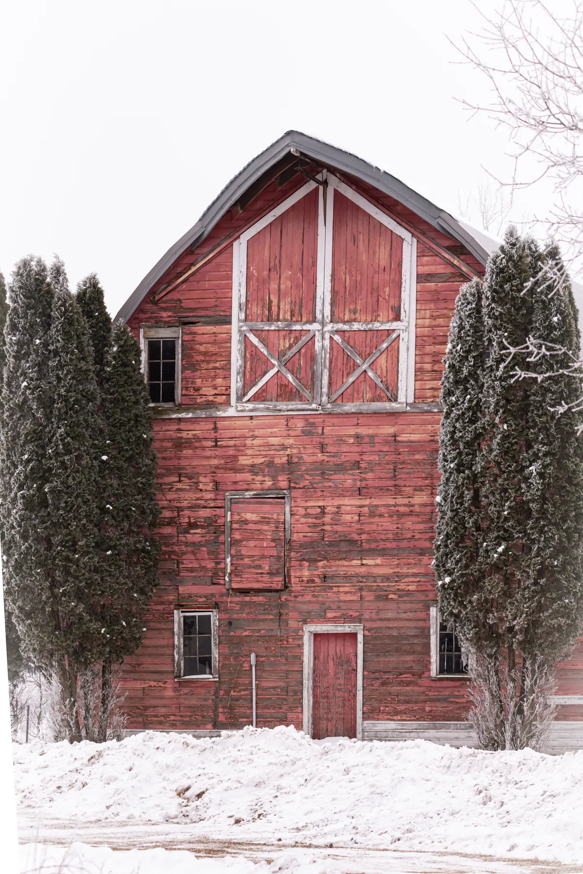 Weathered red barn in winter snow